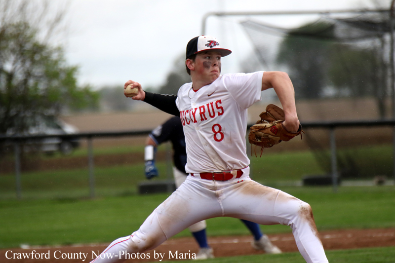 Baseball pitcher in white and red uniform (number 8) mid-throw on a grassy field, glove on left hand and ball in right hand.
