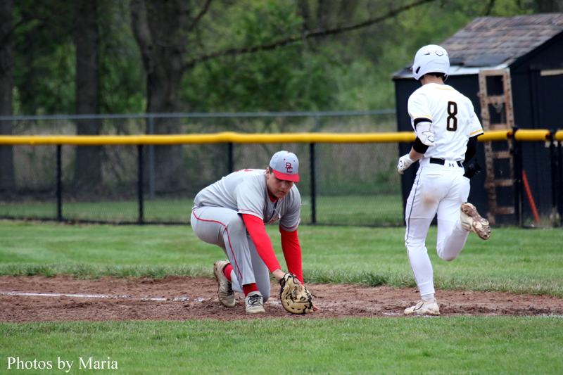 Baseball infield action: fielder in gray and red crouches to field a ground ball as runner with number 8 approaches from the base path.