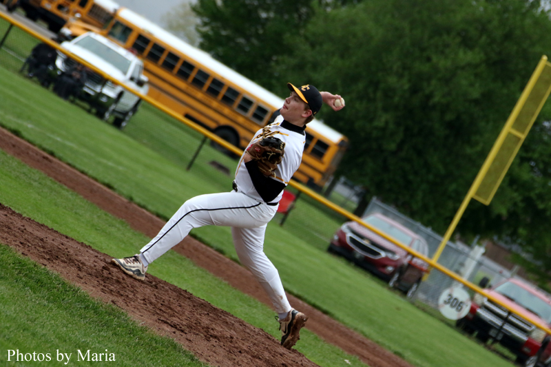 Baseball pitcher in a white uniform throws from the mound as a yellow school bus and green field appear in the background.