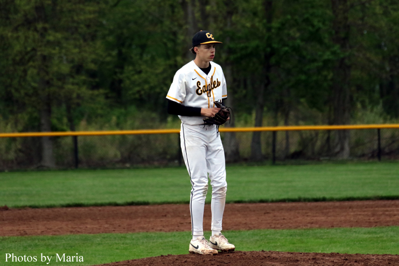 Baseball pitcher in a white Eagles uniform standing on the mound with glove ready to throw.