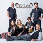 Group portrait of six people posing in a studio with a light backdrop; a StevieMac logo appears above them as a Fleetwood Mac & Stevie Nicks tribute act promo image.