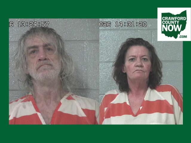 Two side-by-side mugshots: man with long gray hair and beard on the left, woman with dark hair on the right, both in orange-and-white striped jail uniforms against a gray cinder-block wall; timestamp overlays and Crawford County Now logo in corner.