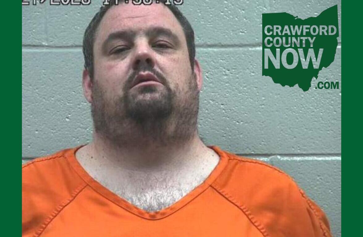 Mugshot of a man in an orange jumpsuit against a gray cinder block wall, with a timestamp in the top-left and Crawford County Now logo on the right.