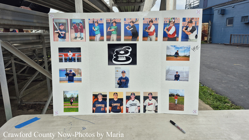 Collage of youth baseball players on a white board, with a central logo image, displayed outdoors near bleachers.