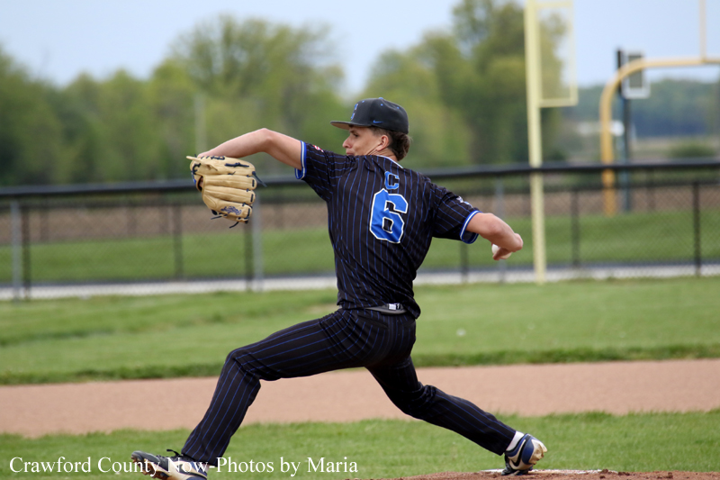 Right-handed baseball pitcher in a dark pinstripe uniform (number 6) delivering a pitch on the mound with glove raised.