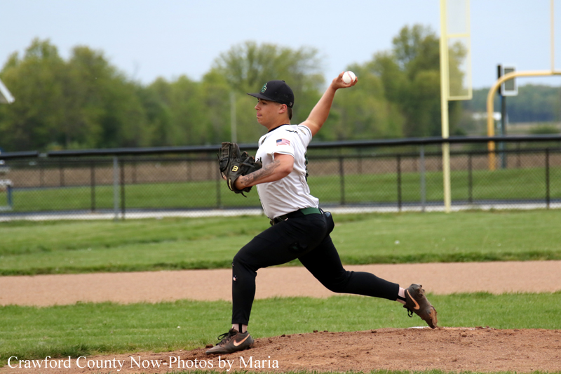 Baseball pitcher in a white uniform throws a pitch from the mound during a game on a grassy field.