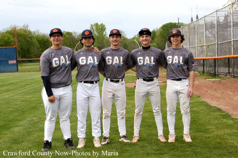 Five young men in gray GAL jerseys pose together on a baseball field with arms around shoulders.