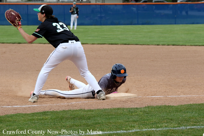 Baseball action: runner slides into second base as the fielder in black jersey reaches for the bag, dust rising from the dirt.