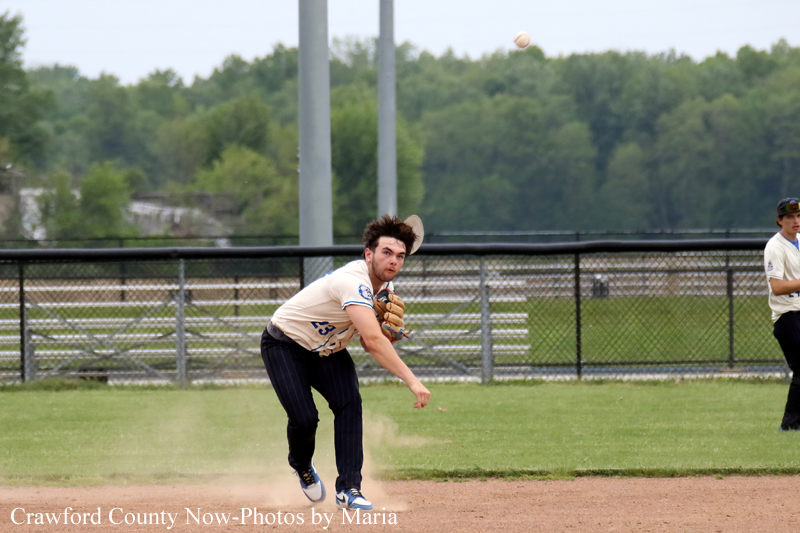 Baseball pitcher mid-throw on a dusty infield during a game