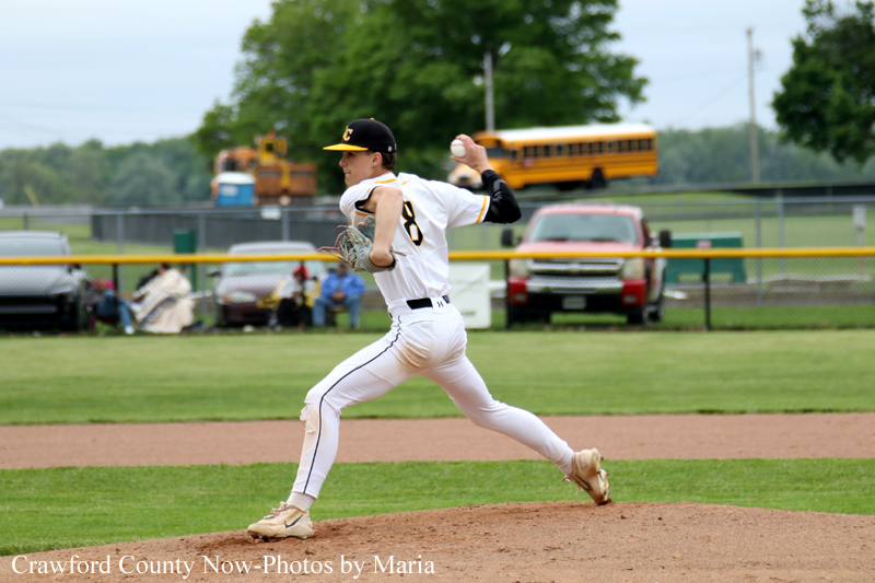 Baseball pitcher in white uniform mid-throw on the mound during a game.