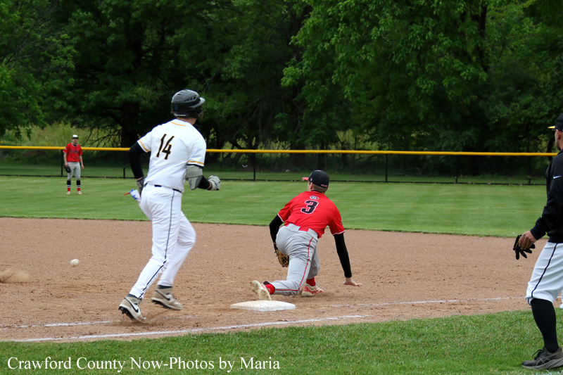 Baseball scene: a runner in red slides into second base as the white-uniformed fielder approaches; ball near the infield dirt.