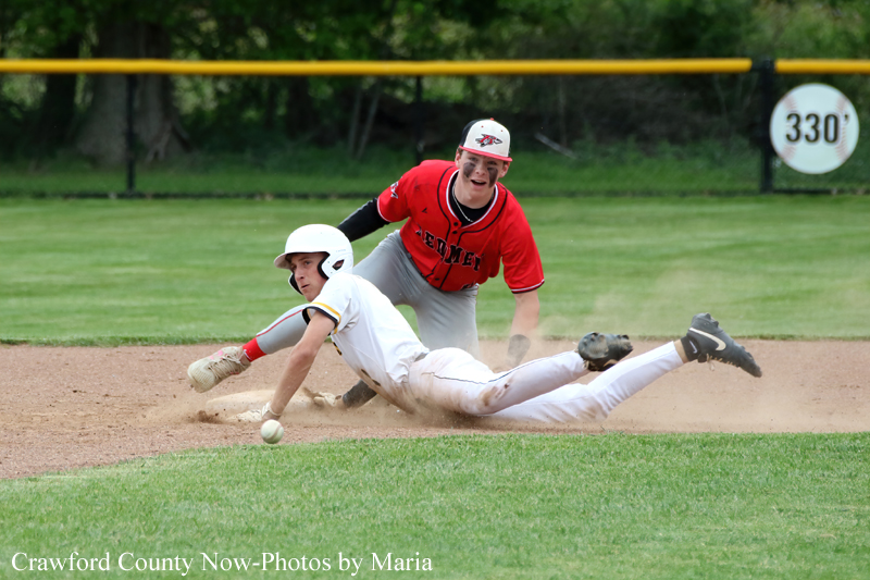 Two baseball players collide at a base: a white-uniform runner slides headfirst while a red-uniform fielder reaches to tag him.