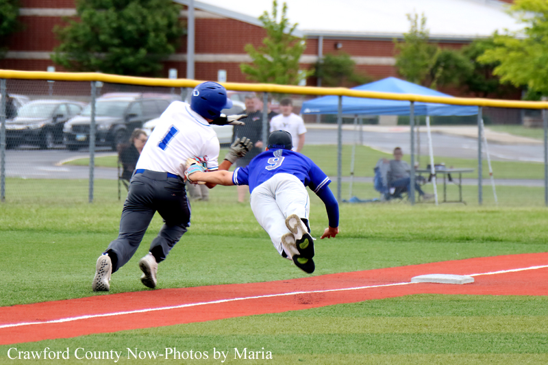 Baseball game action: blue baserunner slides into a base as the white-uniformed fielder reaches to tag him.