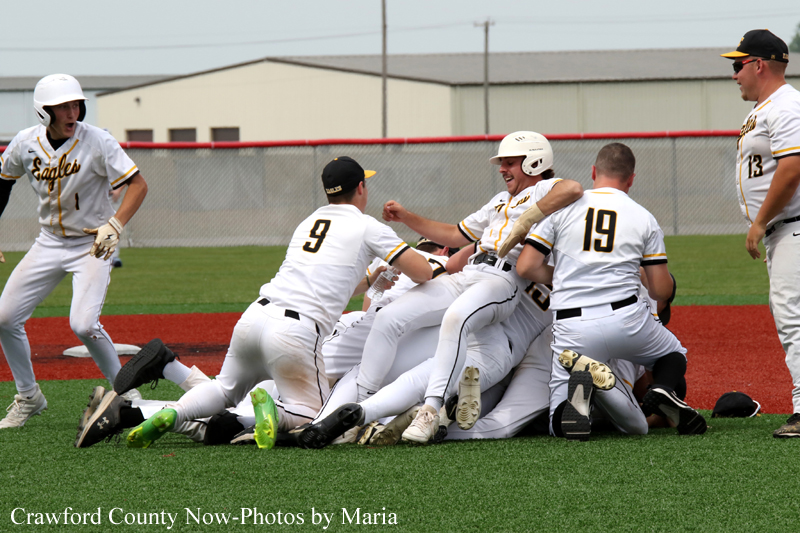 Baseball players in white uniforms celebrating in a pile on the field after a play