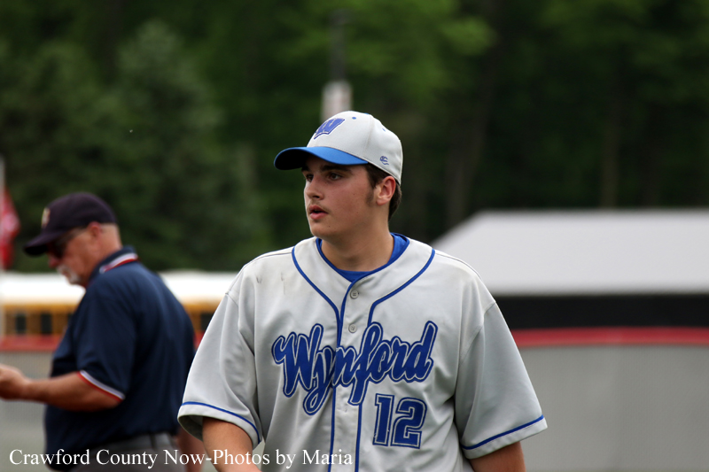 Baseball player in a gray Wyford jersey with number 12, standing on the field during a game.
