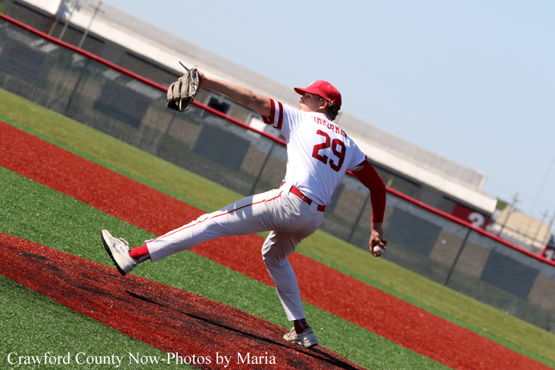 Baseball pitcher in white and red uniform delivering a pitch on the mound during a game