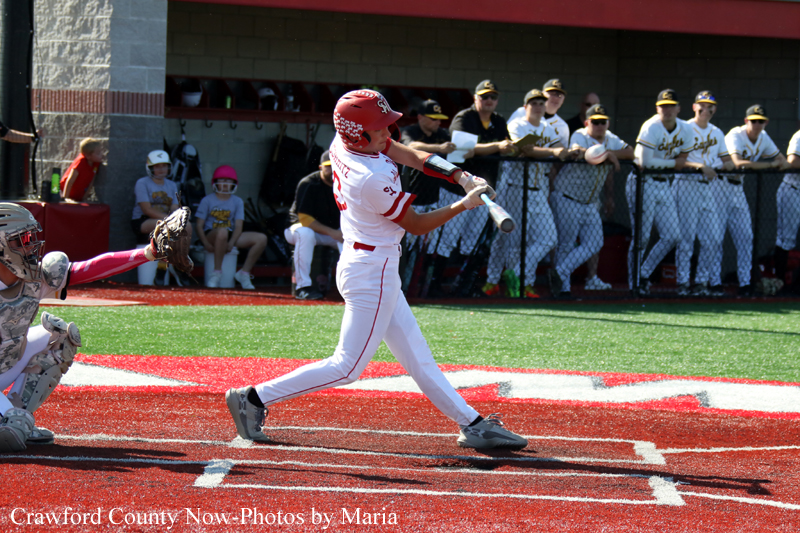 Baseball batter in white uniform swings at a pitch at home plate while the catcher Lunges behind.