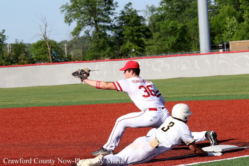 Baseball action: a fielder in white and red reaches with his glove as a baserunner slides into second base on a dirt infield.