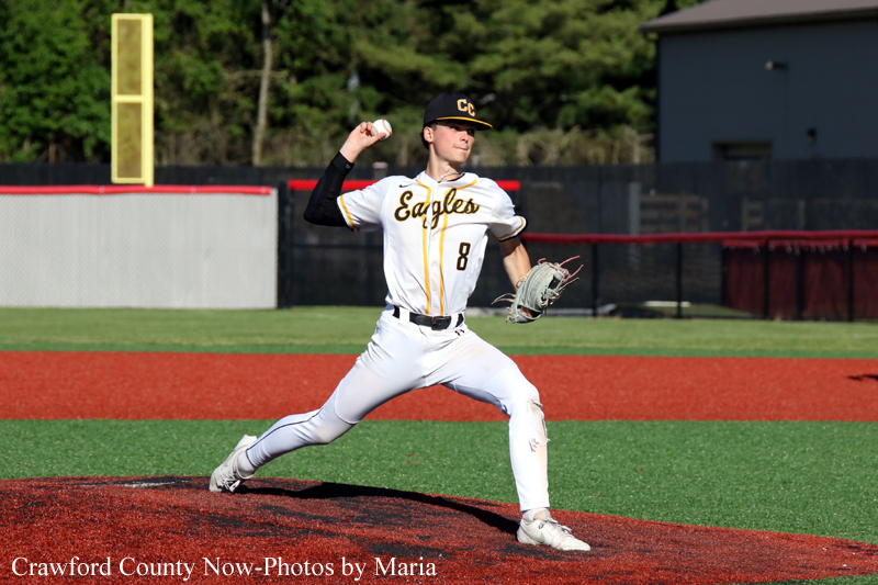 Baseball pitcher in white Eagles uniform delivering a pitch on the mound.