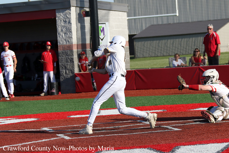 Baseball batter in white swings as catcher in white gear dives to the right during a game.