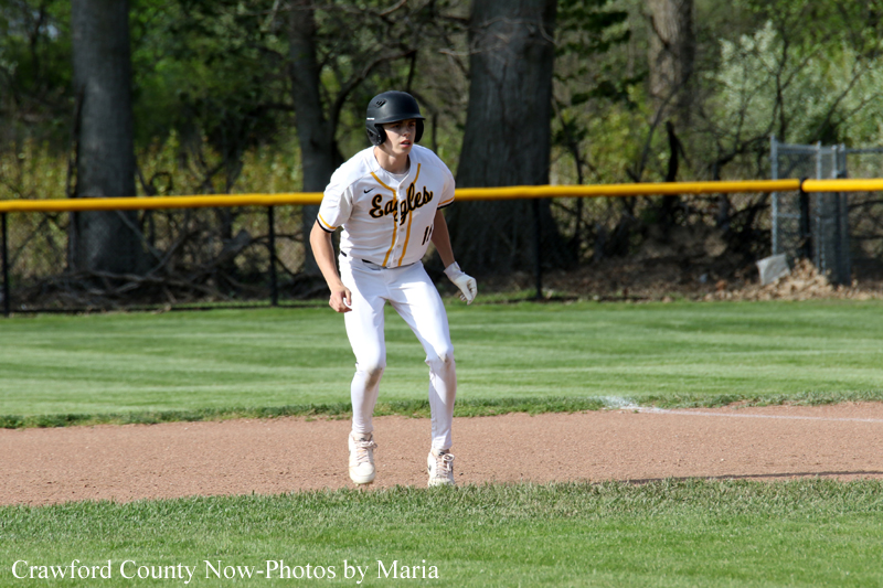 Baseball player in a white Eagles uniform on infield dirt, ready to run, helmet on.