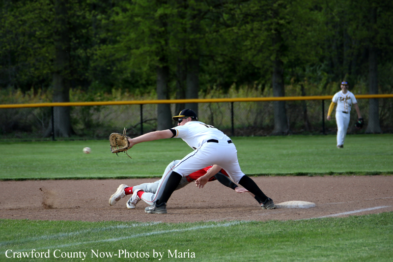 Baseball play at second base: infielder reaches with glove to tag a sliding runner as the ball approaches.