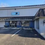 Exterior view of Bucyrus Veterinary Services building with blue sign, glass doors, and a parking lot nearby