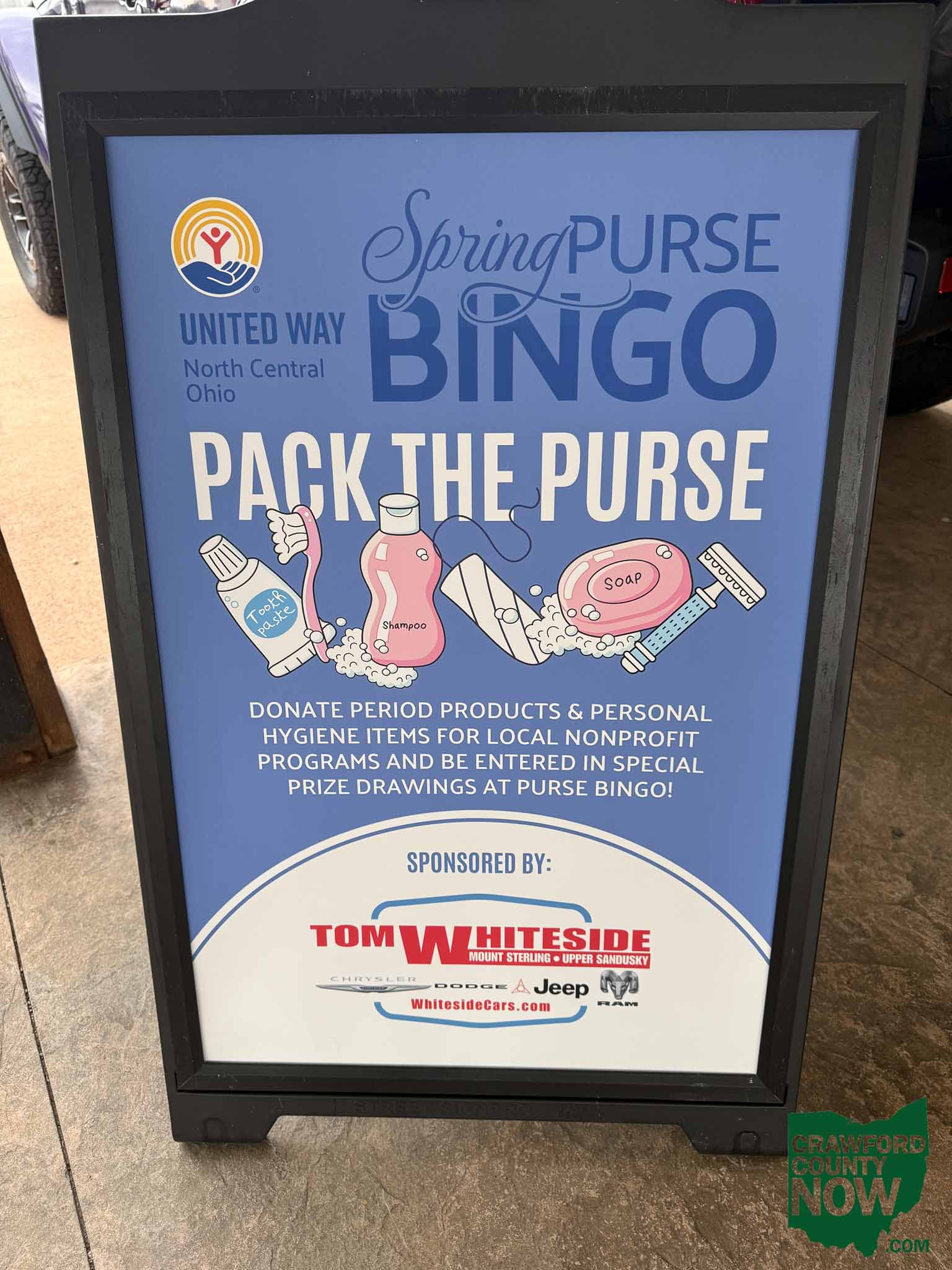 United Way North Central Ohio Spring Purse Bingo sign with logo and illustrations of hygiene products on a blue background (informational poster).