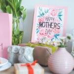 Pink Mother's Day cards with floral print and 'Happy Mother's Day' message among gifts and decor.