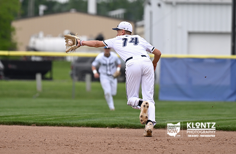 Baseball pitcher in white uniform with number 74 releases a pitch from the mound, glove extended toward the infield.