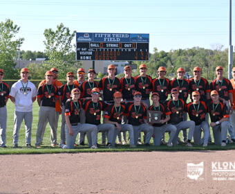 Baseball team posing with a trophy on the field; scoreboard in the background reads Fifth Third Field.