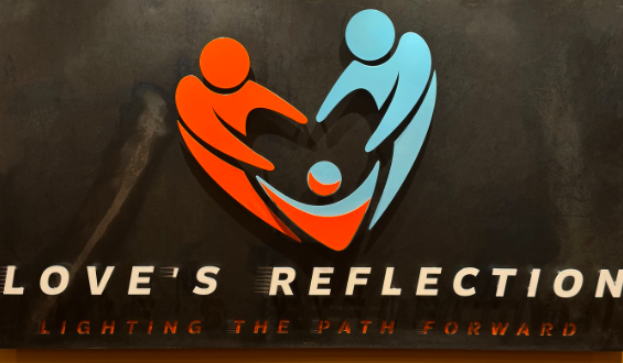Logo for Love's Reflection: a heart formed by two stylized figures reaching toward a child, with the tagline 'Lighting the path forward' below.