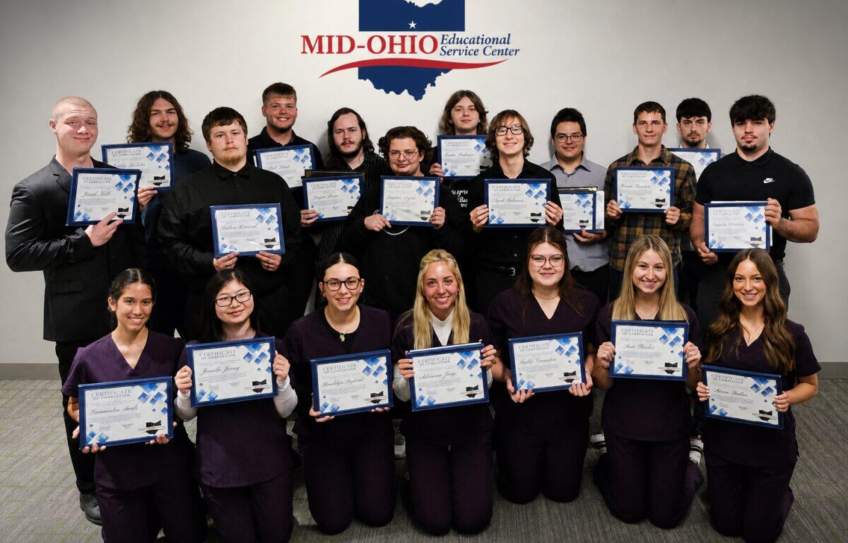 Group of students posing with certificates in front of a Mid-Ohio Educational Service Center banner.