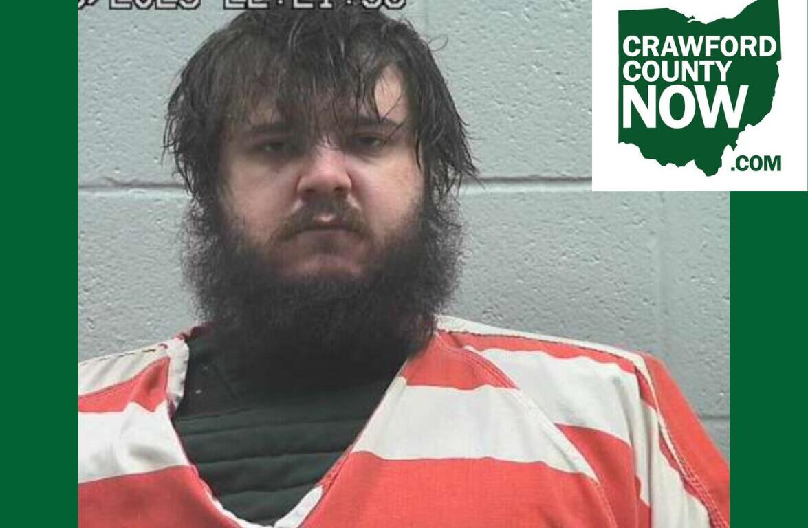 Mugshot of a bearded man in an orange jumpsuit against a gray wall; timestamp overlay and Crawford County Now logo in the corner.