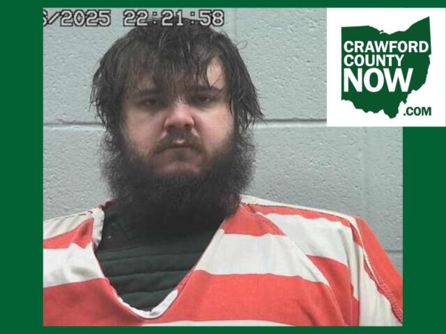 Mugshot of a bearded man in an orange jumpsuit against a gray wall; timestamp overlay and Crawford County Now logo in the corner.