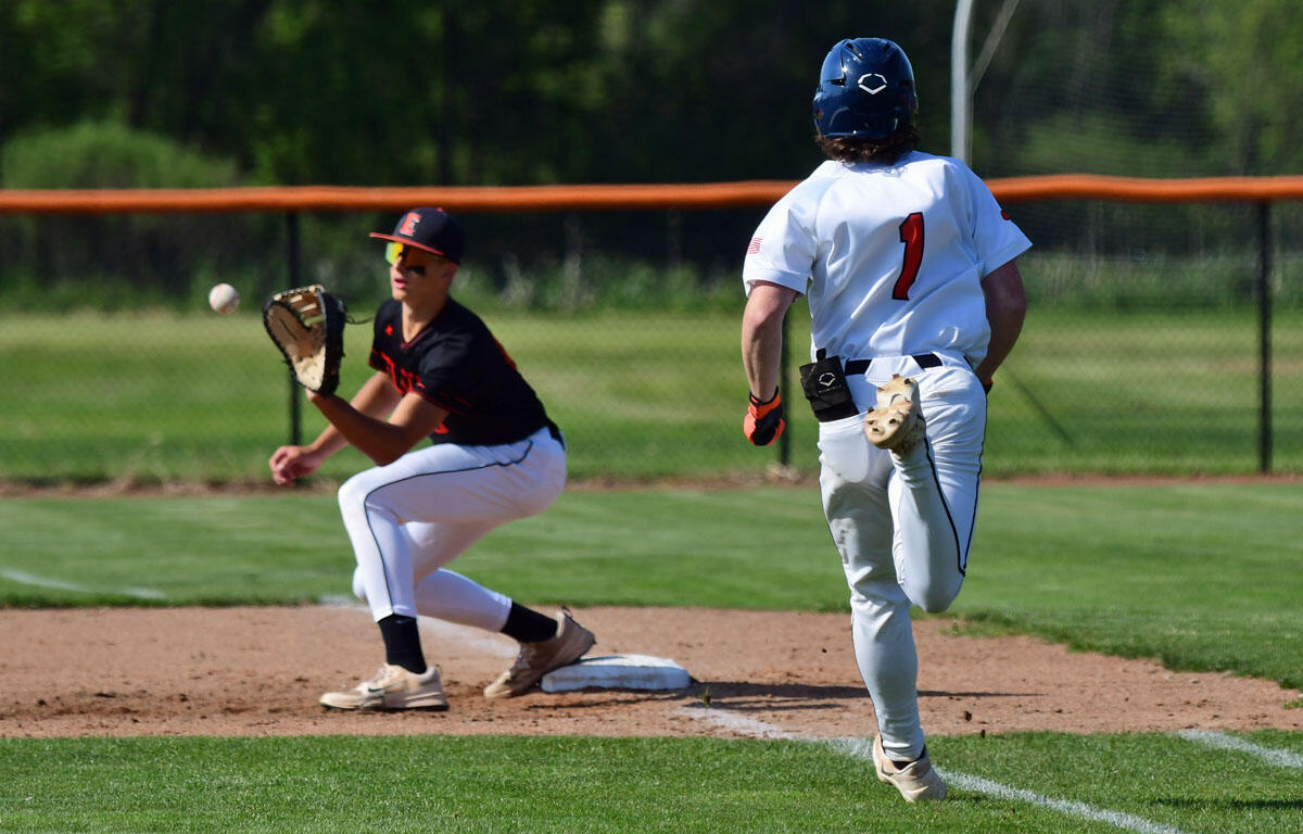 Baseball game: a runner in a white uniform with number 1 sprints toward a base while a fielder in a black uniform reaches to field a ball near the infield dirt.