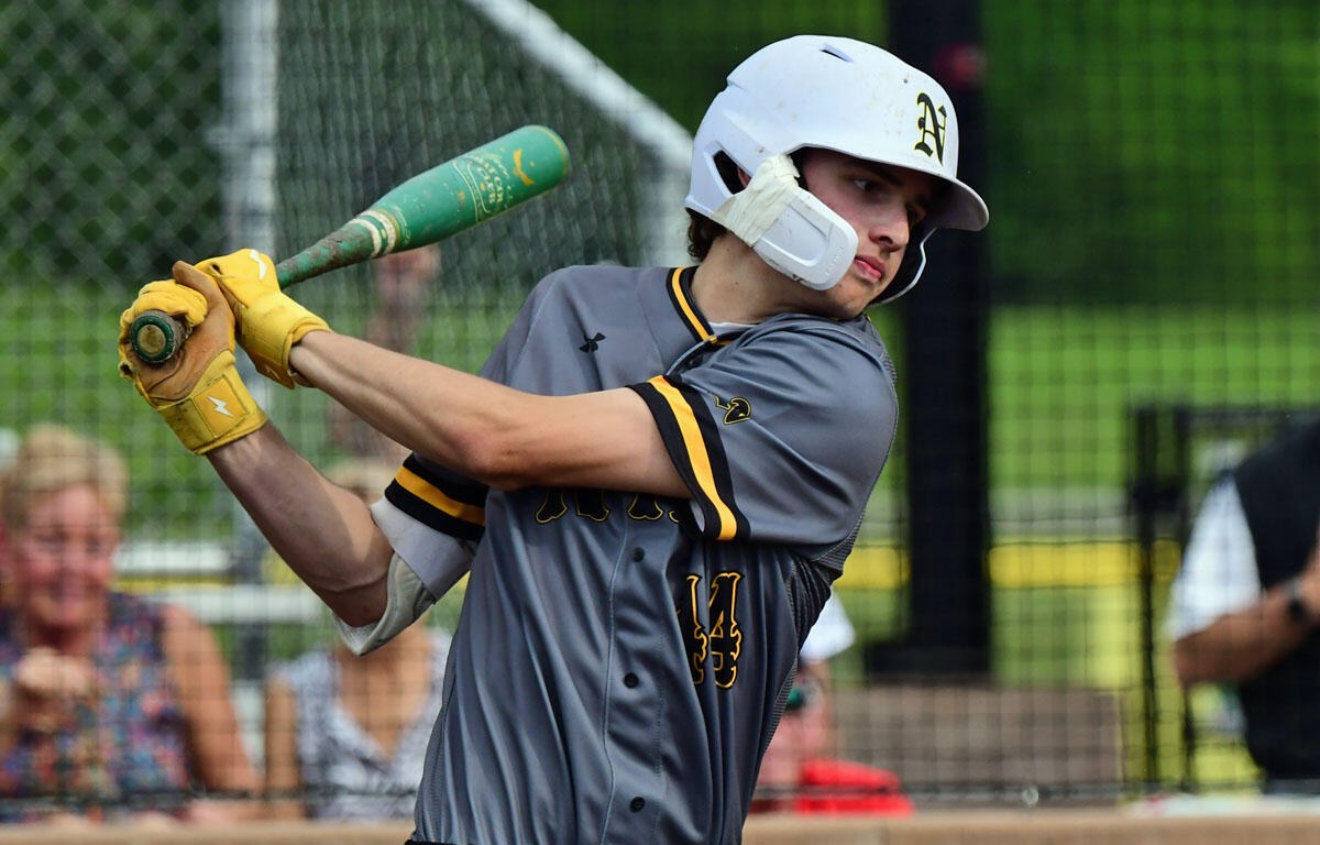 Baseball batter in gray uniform swings a green bat, wearing yellow gloves and a white helmet, action shot at the plate.