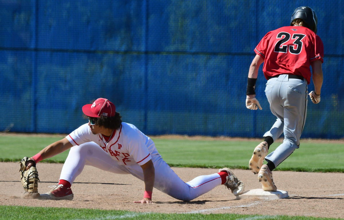 Baseball infielder in white slides into the base as a red-uniformed baserunner (#23) approaches.