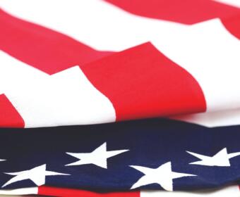 Close-up of the American flag, showing red stripes and white stars on a blue field.