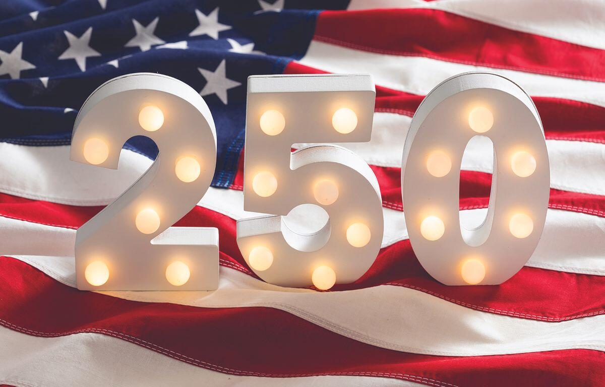 Lit marquee numbers 2 5 0 in front of an American flag backdrop.