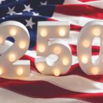 Lit marquee numbers 2 5 0 in front of an American flag backdrop.