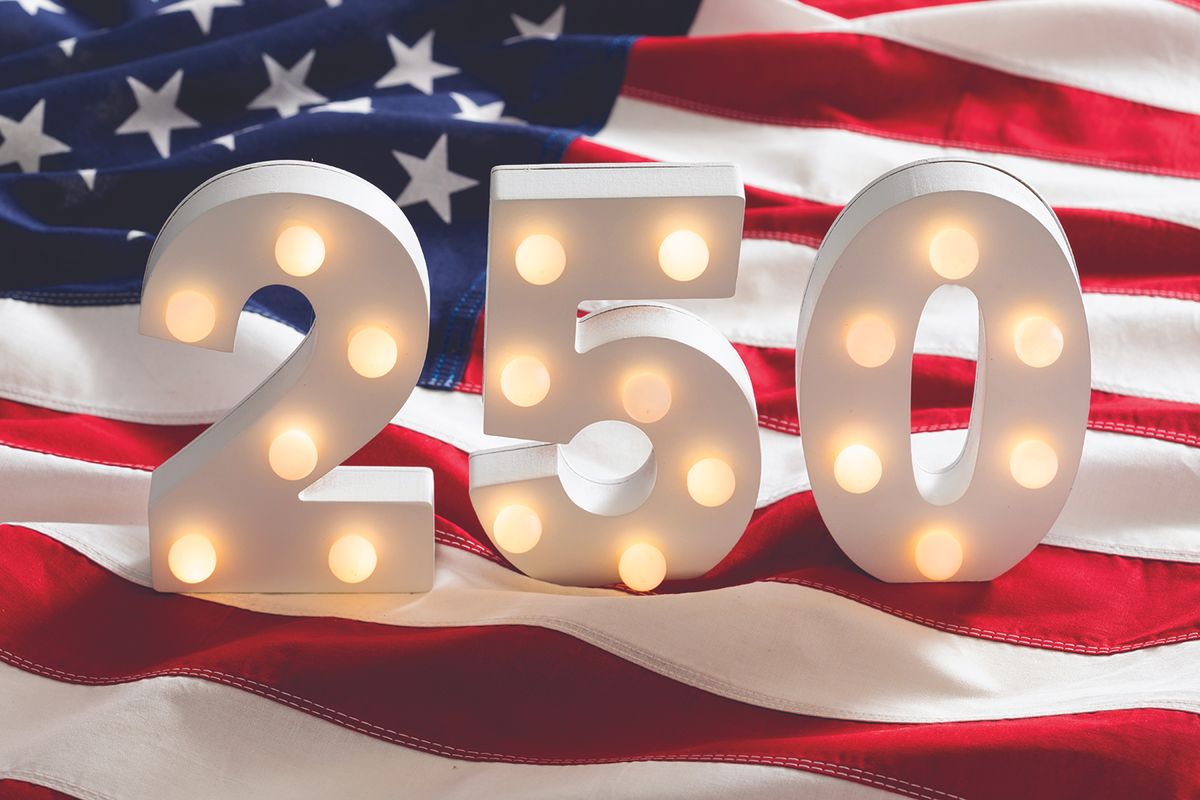 Lit marquee numbers 2 5 0 in front of an American flag backdrop.