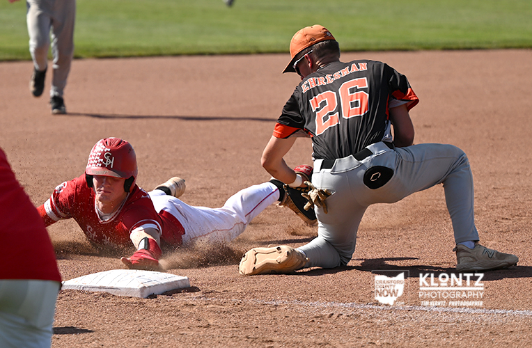 Baserunner slides into second base as a fielder reaches to tag him on a dusty infield pose