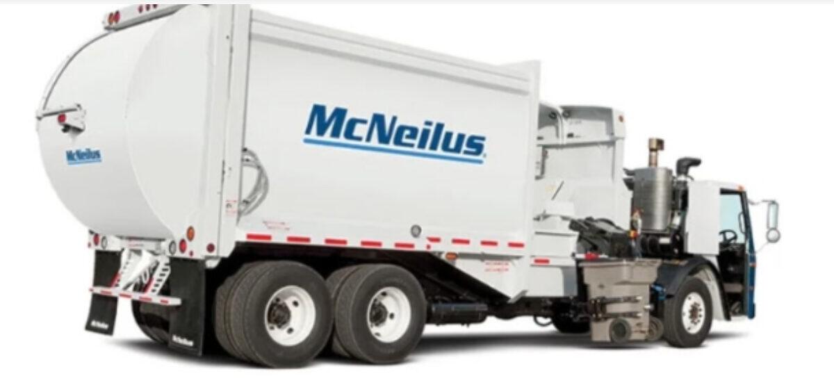 White McNeilus concrete mixer truck with a large rotating drum, viewed from the side.